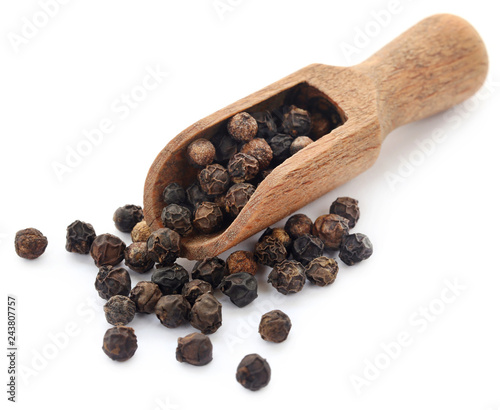 Black peppers on wooden scoop