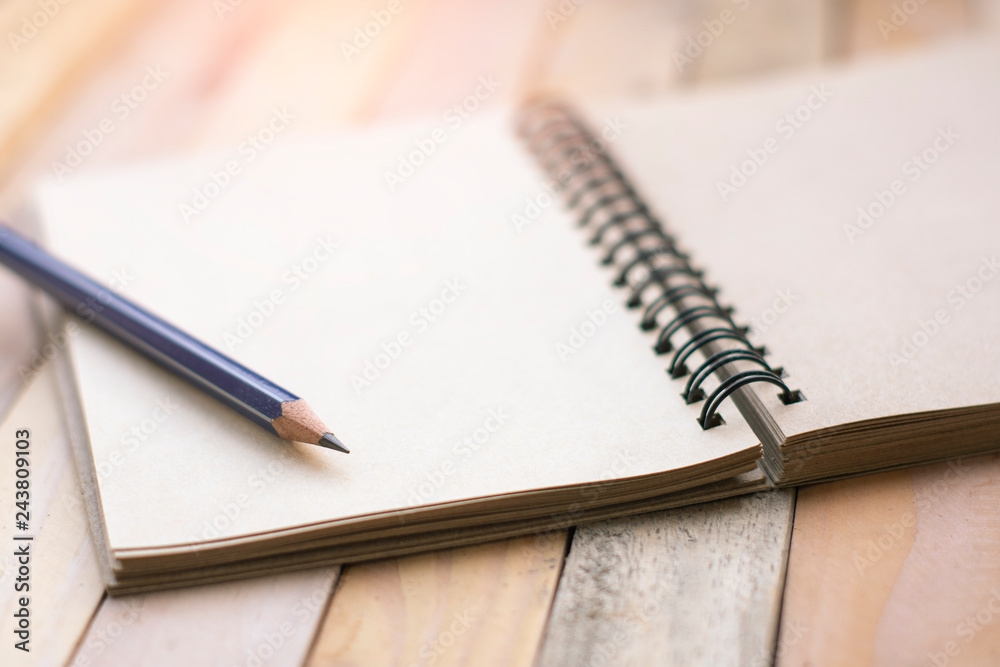 Notepad with pencil on wood board background. Notepad with pencil on wood board background.
