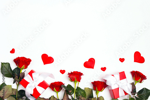 Border of gifts, rose flowers and decorative hearts on white background. Place for text, top down composition.
