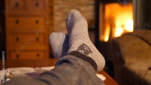 Fotografie Feet with socks close up with orange bright fire burning in the background warm,