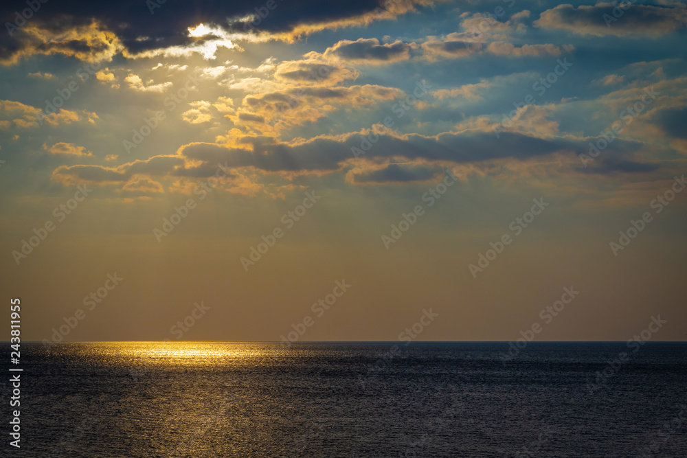 Seascape with bright moon and clouds. A golden reflection of light on the sea surface.