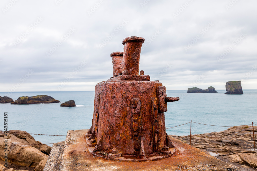 monument of a rusty bollard on the beach