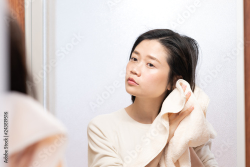 asian female wiping hair with towel in bathroom