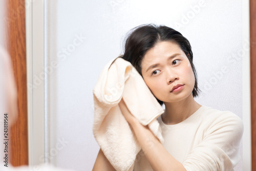 asian female wiping hair with towel in bathroom