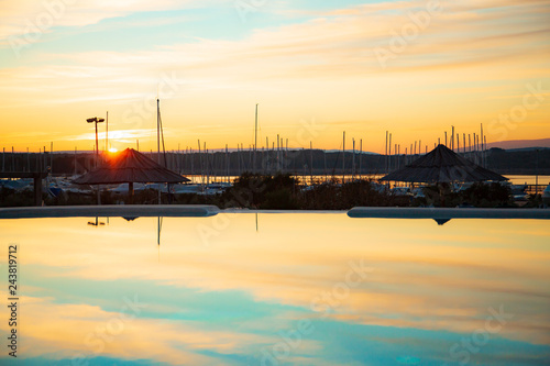 Sonnenuntergang, im Vorderund ein Hafen, Schiffe, Marina