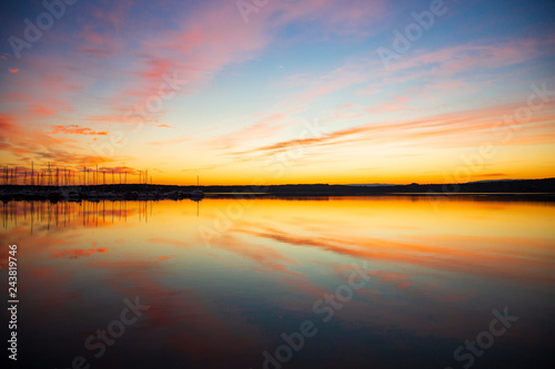 Sonnenuntergang  im Vorderund ein Hafen  Schiffe  Marina