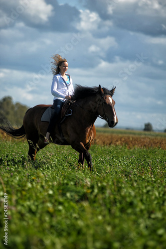 blonde riding a horse in a field