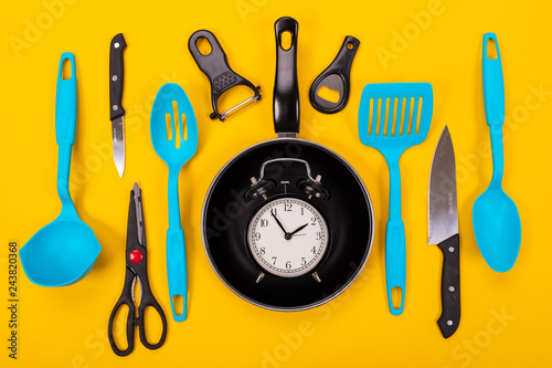 Schilderij op canvas Close up portrait of frying pan with set of kitchen utensils on yellow backgroun