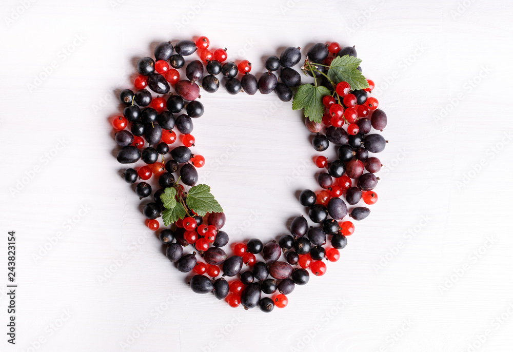 Obraz premium Black gooseberries blackcurrants and redcurrants. Fresh summer berries on white table. Top view. Flat lay.