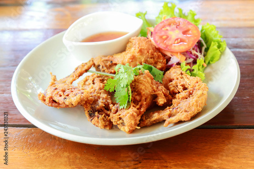 Fried chicken wing on white dish.