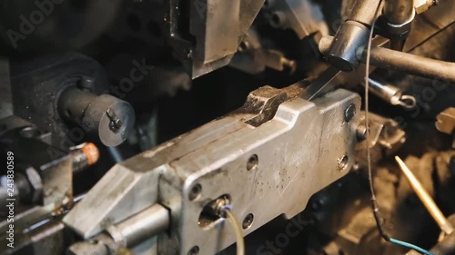 CNC equipment for the production of compression springs, cylindrical screw springs. Process of manufacturing springs for stretching. Close up.