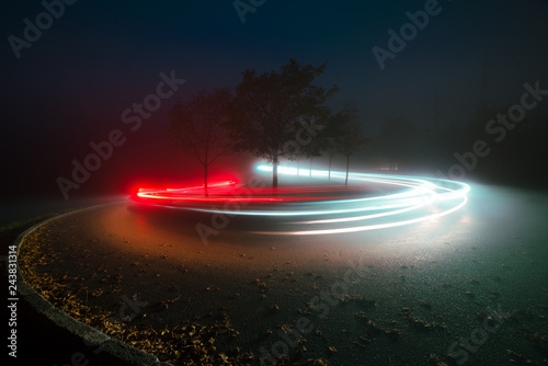 View of abstract shines on road between fog at night photo