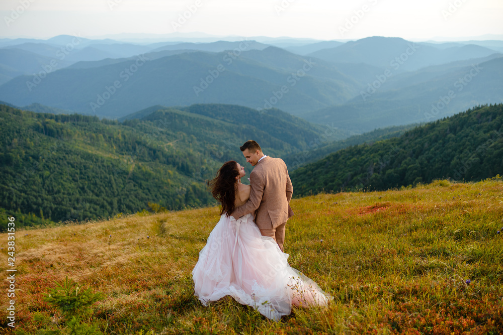 Stylish young bride and groom stand in boat on background cloude sky sea and mountains of Montenegro