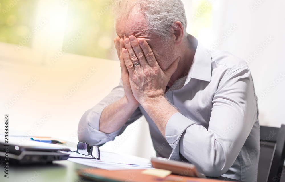 Stressed businessman sitting in office, light effect Stressed businessman sitting in office, light effect