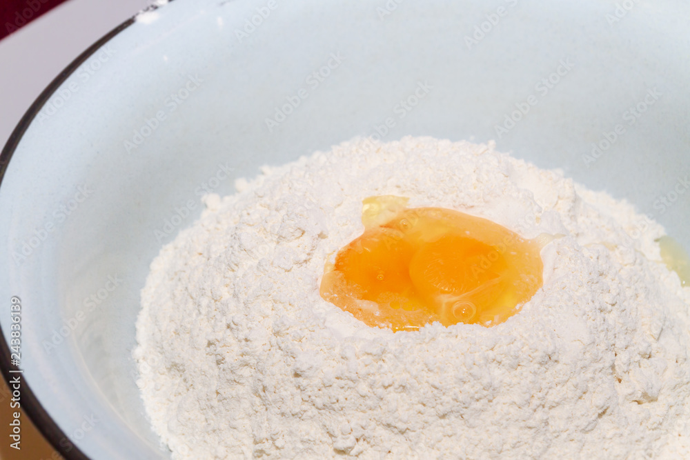 The egg is divided into white flour in the bowl The egg is divided into white flour in the bowl