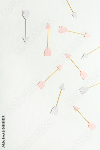 Paper Cupid arrow symbols on white background. Flat lay, top view Valentines Day background love concept.