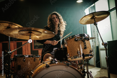 Woman playing drums during music band rehearsal