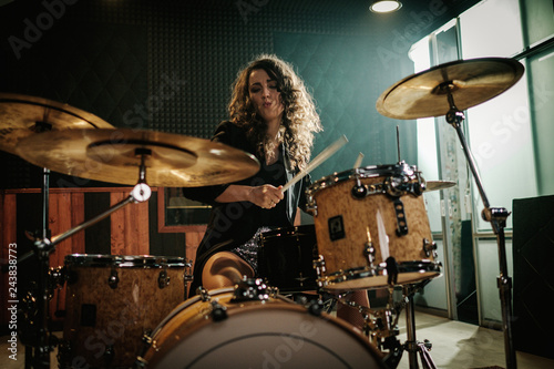 Photo Woman playing drums during music band rehearsal