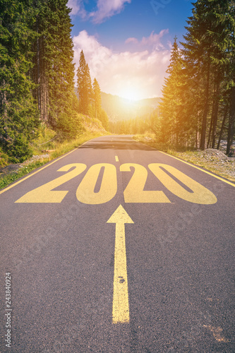 Empty asphalt road and New year 2020 concept. Driving on an empty road in the mountains to upcoming 2020 and leaving behind old 2019. Concept for success and passing time.