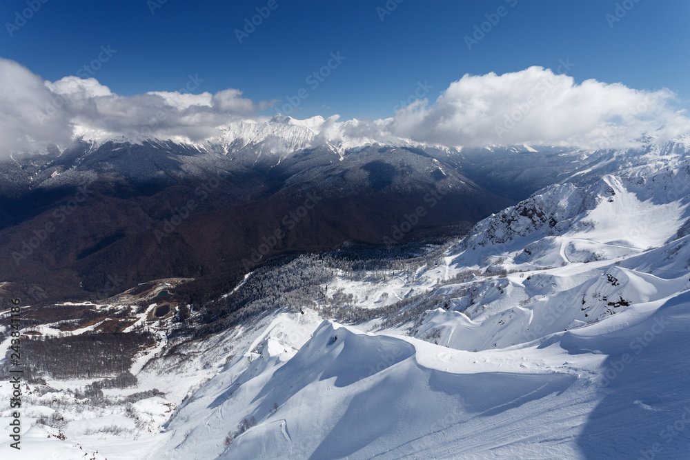 Krasnaya Polyana, Sochi, Russia. View of the slopes of Rosa Khutor. Winter in the mountains, white snow and blue sky