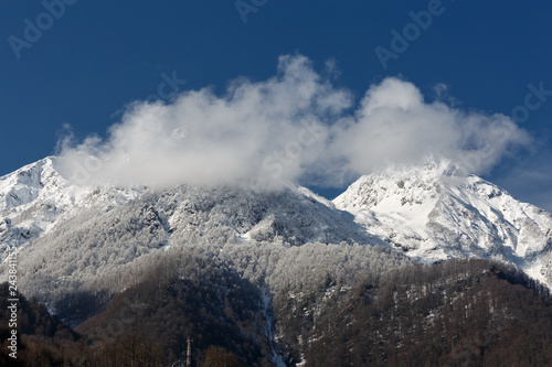 Krasnaya Polyana, Sochi, Russia. The Aibga ridge in the snow. Two summit in the clouds © rzrs