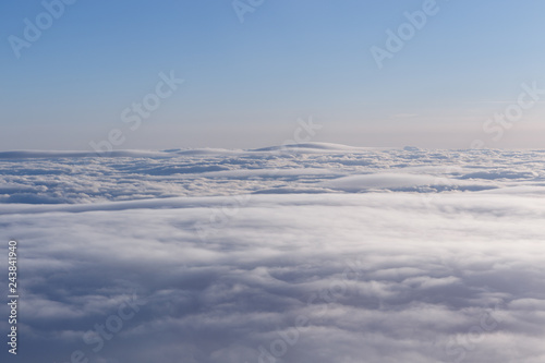 A smooth layer of clouds high in the sky. View from the window of the aircraft in flight