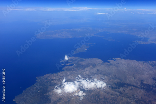 Top view of a flying aircraft on the sky, sea and land