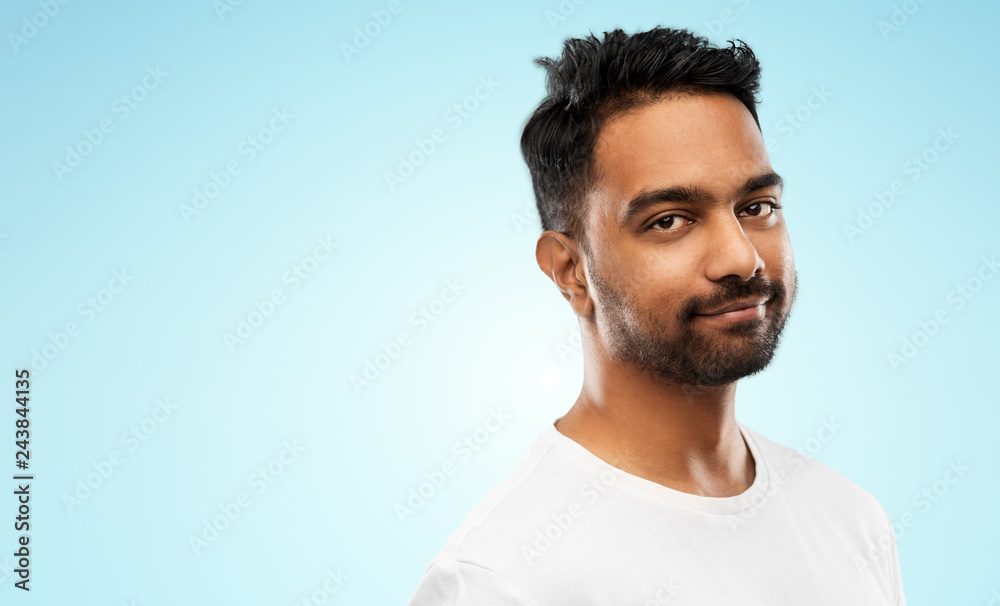 people concept - smiling young indian man over blue background people concept - smiling young indian man over blue background