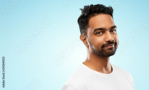 people concept - smiling young indian man over blue background