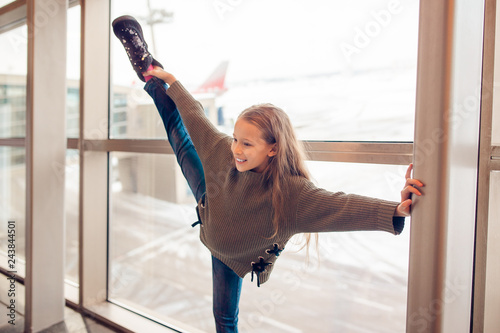 Fototapeta Naklejka Na Ścianę i Meble -  Little girl in airport near big window while wait for boarding