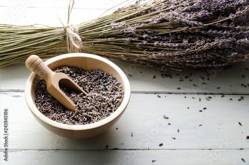 Fototapeta Naklejka Na Ścianę i Meble -  Tied Bunch of Dried Lavender Stems with Bowl of Buds on Wood Planked Table