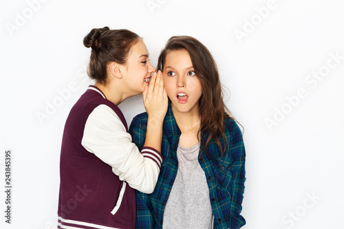 friendship, communication and people concept - happy teenage girls gossiping or sharing secrets over white background