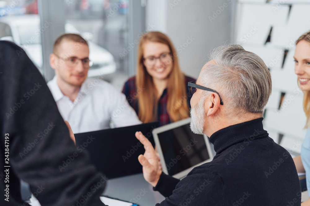 Senior team leading talking to his business team Senior team leading talking to his business team