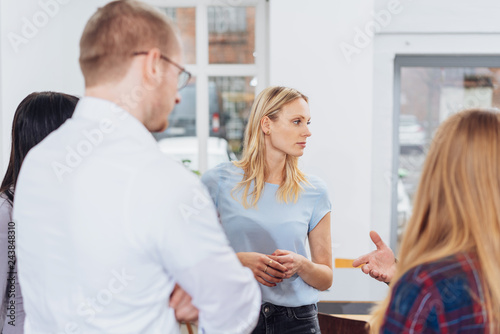 Woman standing listening in a business meeting © contrastwerkstatt