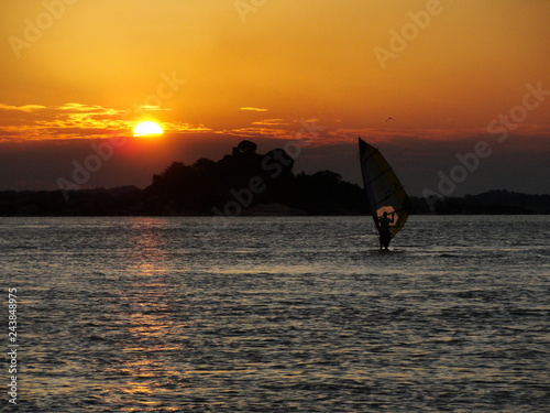 Person training windsurf in the holidays with the sunset in the background
