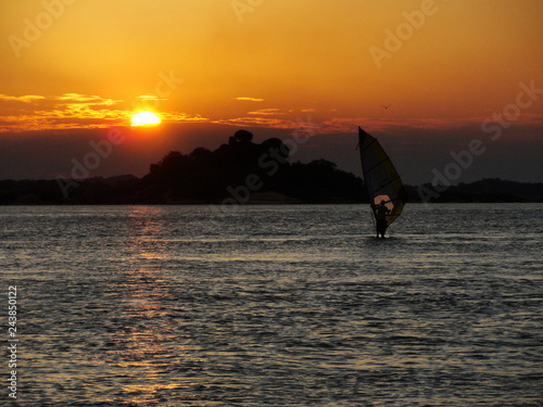 Person training windsurf in the holidays with the sunset in the background