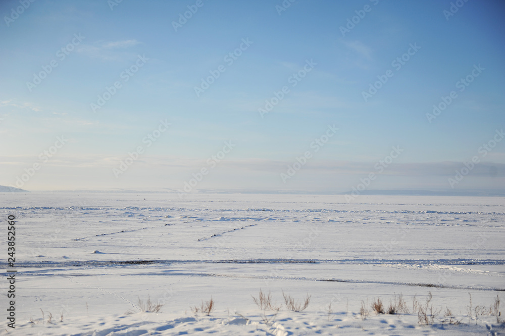 Winter snow landscape. Endless space of a frozen river