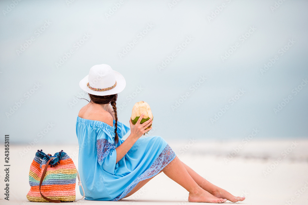 Young woman drinking coconut milk during tropical vacation