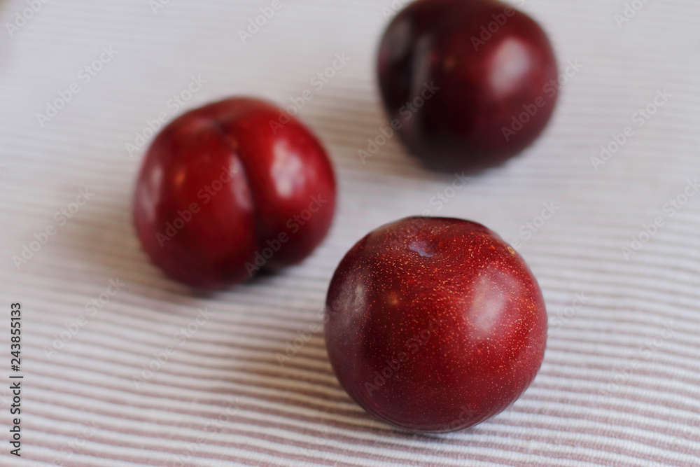 three natural fresh plums on table three natural fresh plums on table