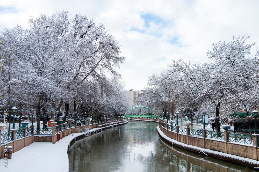 Beautiful Snow Landscape of Porsuk River with The Reflection of trees in Winter season, in Eskisehir, Turkey with beautiful sky view.