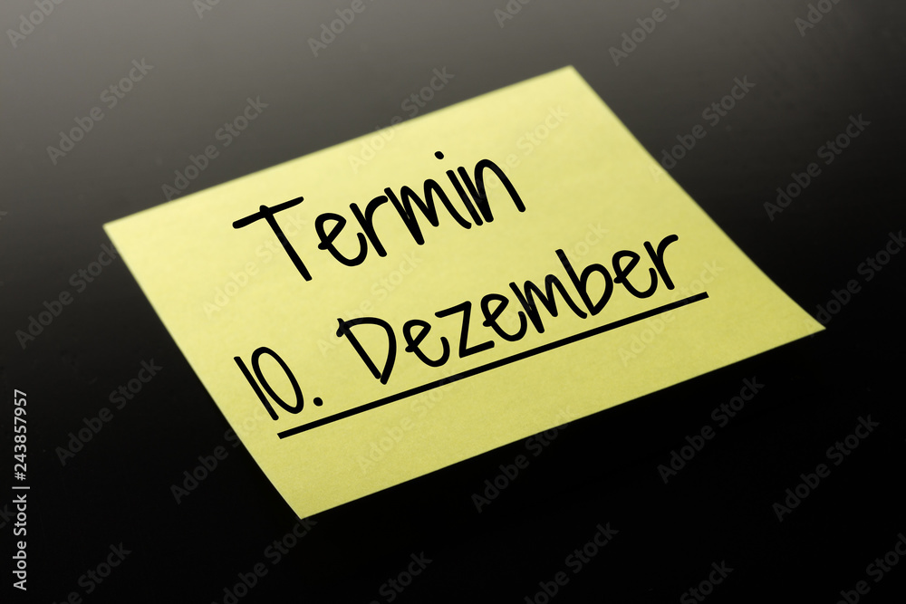 Termin 10. Dezember - gelber Notizzettel dunkler Hintergrund