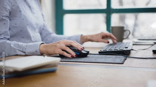 Close up shot of woman hand typing on the laptop keyboard and using computer mouse. photo