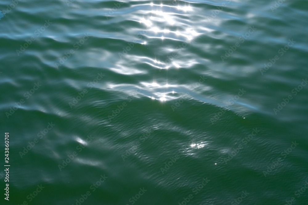 Green water texture with bright patch of light Green water texture with bright patch of light
