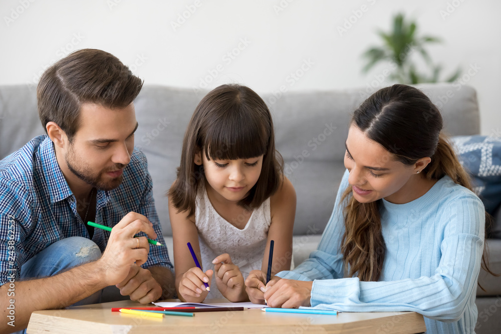 Creative family enjoy drawing with colored pencil on paper, happy mom and dad help kid daughter teaching little focused attentive child learning to draw playing having fun developing concentration Creative family enjoy drawing with colored pencil on paper, happy mom and dad help kid daughter teaching little focused attentive child learning to draw playing having fun developing concentration