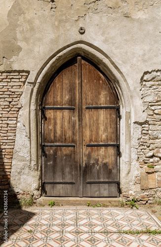 Old door on the façade of stone building