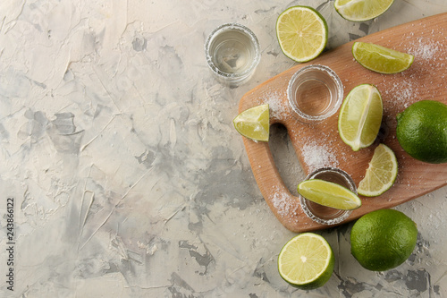 gold tequila in a glass shot glass with salt and lime on a light concrete background. bar. alcoholic beverages. view from above. with space for text