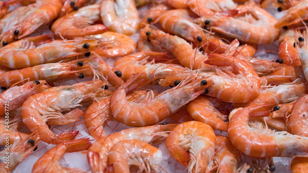 Pink fresh frozen shrimps with ice in a supermarket or fish shop. Uncooked seafood close up background. Fresh frozen prawns, delicacies, sea food concept, close up. Pink fresh frozen shrimps with ice in a supermarket or fish shop. Uncooked seafood close up background. Fresh frozen prawns, delicacies, sea food concept, close up.