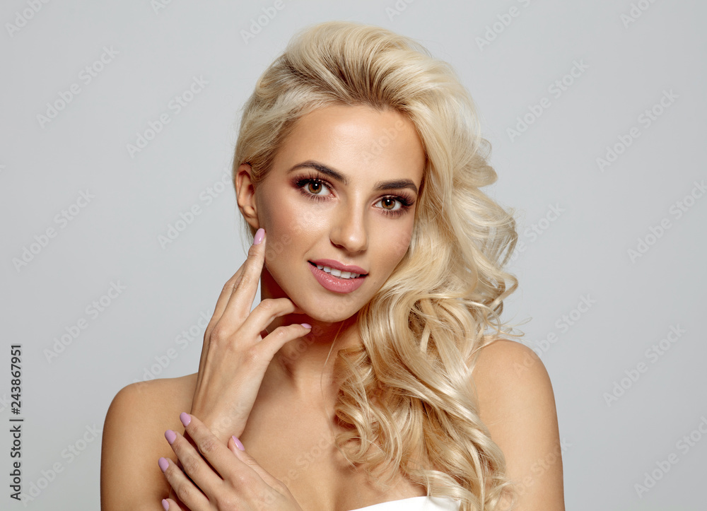 Blond bautiful woman touching her cheek isolated on gray background Blond bautiful woman touching her cheek isolated on gray background