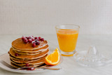 Pancakes with cranberries and maple syrup on marble background