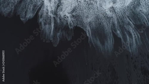 Waves break on a black sand beach on the coast of Maderia Island, Portugal